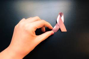 Female hand holding breast cancer awareness ribbon