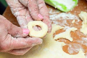 Female hands making bagels out of the dough close up