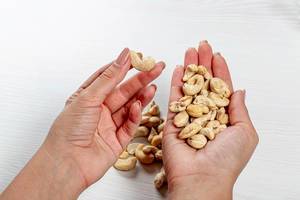 Female hands with cashew nuts. Healthy food concept