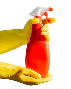 Female hands with yellow gloves holding a red spay bottle. Isolated on white background. Bottle mock up
