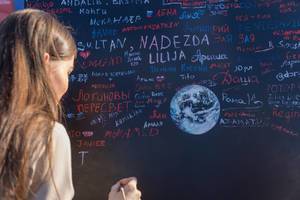 Female soccer fan writing on black board with paint brush