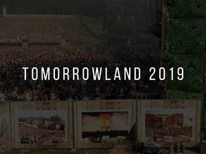 Festivalisten vor der Open-Air Festivalbühne im Tomorrowland 2019, mit kleiner Kunstausstellung im Vordergrund