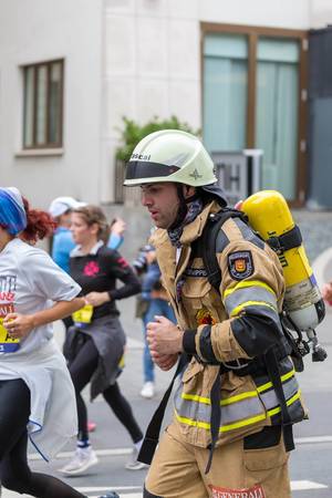 Feuerwehrmann beim Frankfurt Marathon läuft in der Uniform mit Ausrüstung