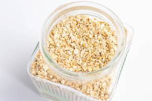 Fine oats in a glass jar on white background