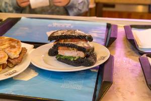 Fisch-Burger mit Lachs und Tintenfisch in dunklen Buns