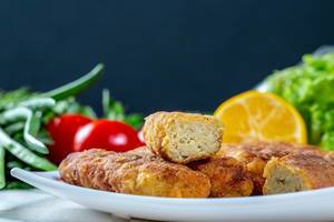 Fish sticks in breadcrumbs on a plate with vegetables