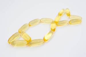 Fish symbol out of fish oil capsules on a white background