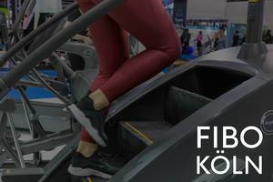 Fitnesstraining mit einem Treppenlaufband auf der Sportmesse, neben dem Bildtitel "Fibo Köln"