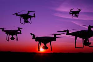 Five drones in the sky at sunset