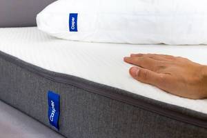 Flache Hand liegt auf der atmungsaktiven Matratze von Casper, die durch Memoryschaum den Körper im Schlaf entlastet