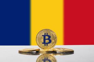 Flagge von Rumänien in Unschärfe mit Arrangement aus goldenen Bitcoins im Vordergrund