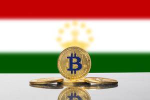 Flagge von Tadschikistan mit goldener Münze der Kryptowährung Bitcoin im Vordergrund