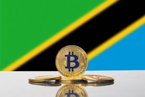 Flagge von Tansania mit vier goldenen Bitcoins im Vordergrund