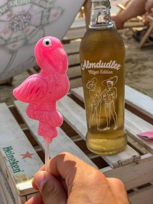Flamingo Lutscher in der Hand und eine Flasche Almdudler Flitzer Edition im Hintergrund