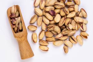 Flat lay above Pistachios with wooden Spatula