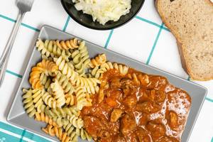 Flat lay above served colorful Macaroni with meat Goulash