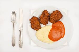 Flat lay above served meatballs with mashed potatoes and tomato sauce