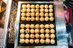 Flat lay of takoyaki balls on food tray