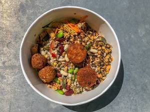 Flat-lay shows healthy, vegetarian salad by Picadeli, with meatless vegetable balls of tomatoes and basil, Powerkornmix, beans, carrots and pasta