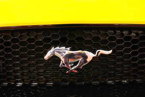 Ford Mustang GT Emblem, Nahaufnahme auf schwarz-gelbem Hintergrund