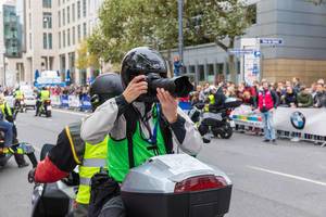 Fotograf rückwärts sitzend und fotografierend beim Frankfurt Marathon