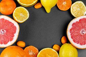 Frame of different citrus fruits on a black background with a free space in the middle (Flip 2020)