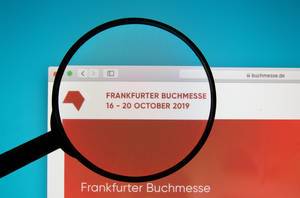 Frankfurter Buchmesse website on a computer screen with a magnifying glass