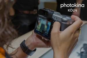 Frau hält einen Hasselblad-Fotoapparat neben dem Bildtitel "photokina Köln"