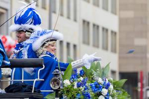 Frau in Uniform der Blauen Funken wirft Zuschauern Päckchen zu - Kölner Karneval 2018