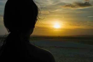 Frau schaut von den weißen Sanddünen in Mui Ne, Vietnam in den Sonnenuntergang