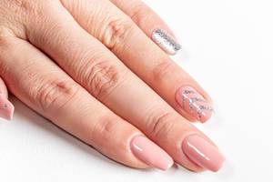 Frauenhand mit langen Fingernägeln und neuer Maniküre