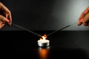 Frauenhände lassen zwei Wunderkerzen mit Hilfe der Kerzenflamme brennen