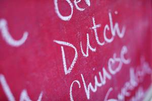 Fremdsprachen: das Wort "Dutch" mit Kreide in einer Liste auf einer pinkfarbenen Tafel geschrieben