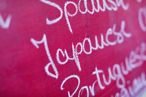 Fremdsprachen: das Wort "Japanese" mit Kreide in einer Liste auf einer pinkfarbenen Tafel geschrieben