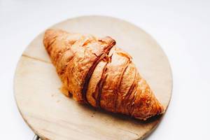 French croissant on wooden board. Close up.