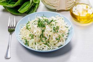 Fresh cabbage and leek salad with olive oil on white wooden background (Flip 2019)