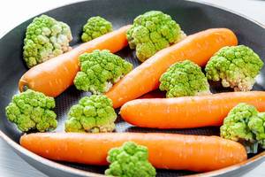 Fresh carrots and broccoli in the pan close-up