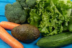 Fresh-Carrots,-Avocado,-Broccoli,-Lettuce-and-Cucumber-on-the-blue-boards.jpg