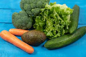 Fresh-Carrots,-Avocado,-Broccoli,-Lettuce-and-Cucumber-on-the-wooden-table.jpg