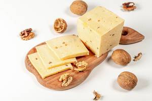 Fresh cheese with walnuts on wooden kitchen Board on white background (Flip 2020)
