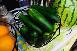 Fresh cucumber on black metal basket