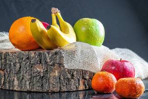 Fresh fruit with wooden stump and burlap on black table (Flip 2019)