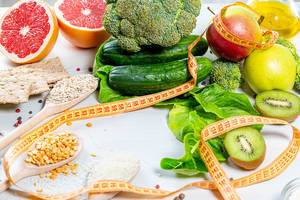 Fresh fruits, vegetables and cereals with measuring tape. Weight loss concept
