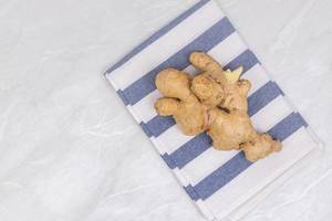 Fresh Ginger on the kitchen dishtowel with copy space on the table