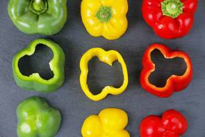 Fresh green, red and yellow pepper, black background