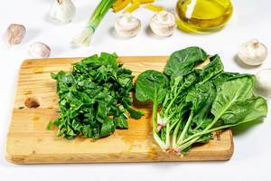 Fresh green spinach bunch and sliced on kitchen Board (Flip 2019)