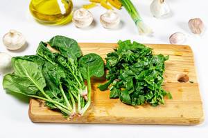 Fresh green spinach bunch and sliced on kitchen Board