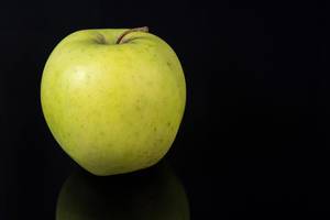 Fresh Healthy Green Apple above black reflective background (Flip 2019)