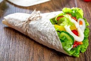 Fresh pita bread with lettuce, tomatoes, bell peppers, onions, carrots and cucumber