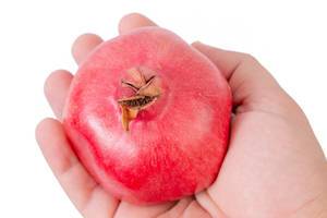 Fresh Pomegranate in the hand above white background (Flip 2019)